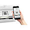 Hand hält Smartphone vor einen weißen Drucker; das Display zeigt einen QR-Code auf dem Drucker-Bildschirm.
