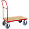 Carretilla roja con plataforma de madera y cuatro ruedas, de pie sobre una superficie gris.