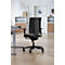 Chaise de bureau noire sur fond clair. La chaise a un dossier en maille et se trouve devant un bureau.
