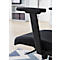 Gros plan sur une chaise de bureau noire. Accoudoir, assise et partie du dossier. Arrière-plan : étagère et tapis.
