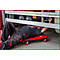 Mécanicien couché sous un camion, travaillant sur son chariot à outils rouge.