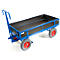 Chariot de transport bleu avec zone de chargement noire. Les roues sont grises avec des jantes rouges. La poignée pour tirer est bleue.