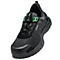 Chaussure de sécurité noire avec des accents verts et un système de laçage rapide. Logo Uvex visible.