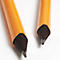 Close-up of two pencil tips lying at a light angle on a white background. The tip is made of black graphite.