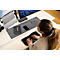 Jeune femme tapant sur un clavier divisé à un bureau. Sur la table : ordinateur portable, écran, bloc-notes, téléphone et lunettes.