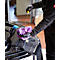 A mechanic checks the oil level of a car. He holds an oil dipstick and a purple cloth.