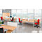 Bureau avec bureaux clairs, chaises rouges et une grande fenêtre donnant sur une ville.