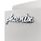 Gros plan sur le logo chromé Phoenix sur une surface gris clair texturée.
