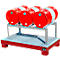 Red barrels on metal construction. The barrels rest on a metal shelf. Below is a metal tray and red painted feet.