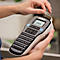 Persoon houdt een draagbare Dymo LM160 labelmaker vast en trekt een vers geprint label eruit.