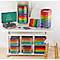 Espace de travail de bureau avec des plateaux colorés, un moniteur et une chaise.