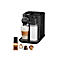 Schwarze Nespresso-Kaffeemaschine mit Milchtank und Latte Macchiato im Glas. Einige Kapseln liegen daneben.