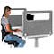 Woman at a desk with partition typing on laptop. Grey wall, white desk, black office chair.
