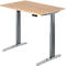 A height-adjustable desk with a light brown tabletop and gray metal legs. The desk has a control unit.