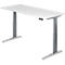 A height-adjustable desk with a white tabletop and grey legs. There is a control panel on the edge of the table.