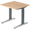 Light brown square standing desk with gray, height-adjustable legs. The tabletop is made of wood-look material.