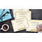 Overhead shot of a desk with certificates, a coffee cup, eyeglasses, a mouse, and a notebook.