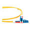 Nahaufnahme eines gelben Glasfaserkabels mit roten und blauen Steckern auf weißem Hintergrund.