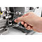 Close-up of a hand inserting a black plug into a hole on a metal housing.