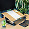 Wooden laptop stand with paper and pencil. Next to it a keyboard and a glass of water with blueberries and mint.