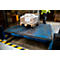 A worker in a yellow jacket loading or unloading boxes on a loading dock.