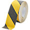Yellow and black striped adhesive tape, rolled, for marking danger areas.