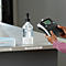 Persoon gebruikt een Dymo labelmaker om labels voor handdesinfectie en maskers te maken op een receptiebalie.