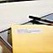 Enveloppe jaune avec adresse et bloc-notes avec stylo.