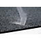 Primer plano de una alfombra gris texturizada con polvo blanco o fibras depositándose en forma de remolino.
