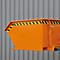 Orangener Container mit gelb-schwarzer Markierung. Im Hintergrund eine graue Fassade.