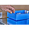 Hand lifting a blue box, another box below. Contents: white syringes. Background: cardboard and metal.