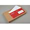 A red document envelope in a brown box, with a white sheet underneath. Text on the envelope.