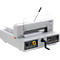Gray paper cutter with operating lever and protective device. The device is on a table.