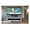GroÃŸer Fernseher mit bunten Zeichentrickfilm-Szenen an einer Wand. Unter dem Fernseher befindet sich ein weiÃŸes Sideboard mit GerÃ¤ten.