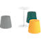 Divers tabourets gris, vert et jaune, à côté d'une table blanche.