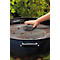 Une main nettoie la grille du barbecue avec une éponge.