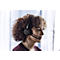 A woman with curly hair wearing a headset. She is looking slightly to the right, where she seems to be holding a conversation.