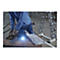 Mann in blauem Anzug bedient Tablet, Projektor leuchtet. Handtuch und Hanteln im Hintergrund.