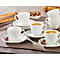 Coffee cup set with saucers, coffee beans and chocolate on a tablecloth.