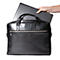 Mallette en cuir noir, avec un ordinateur portable placé à l'intérieur. Une main tient l'ordinateur portable.