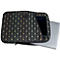 Sacoche pour ordinateur portable noir avec motif, tablette et ordinateur portable à l'intérieur.