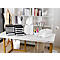 Bureau avec des organiseurs de fichiers noirs, une lampe de bureau blanche, des orchidées et des fournitures de bureau.