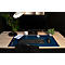 Bureau avec moniteur, clavier et accessoires. Tapis de bureau bleu, une montre et une tasse à café.