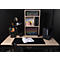 Schreibtisch mit schwarzer Tischplatte, Lampe, Notizblock, Ablagen, Bücher und Accessoires. Schwarzer Hintergrund.
