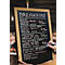 Un menu de petit-déjeuner manuscrit dans un café. Le tableau noir énumère diverses options de petit-déjeuner avec les prix.