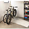 Zwei Fahrräder stehen in einer Garage in einem Fahrradständer. Eines ist ein Fatbike.