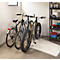 Drei Fahrräder stehen in einer Garage. Eines ist ein Fatbike, die anderen sind normale Fahrräder. Rechts ein Regal mit Zubehör.