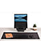 Black laptop on a stand, surrounded by accessories: mouse, keyboard, notebook, potted plant.