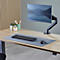 Blue-gray rectangular desk pad with one corner folded over to reveal a black fabric surface. Small company logo.
