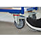 Foot locking cart wheel. Black shoe stepping on the brake lever of a blue cart to stop movement.